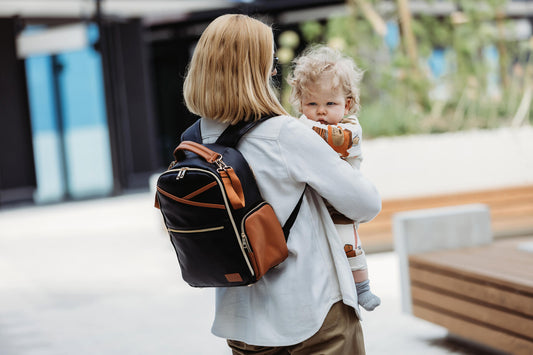 Mother walking outdoors with the lightweight Small Black Coffee Backpack