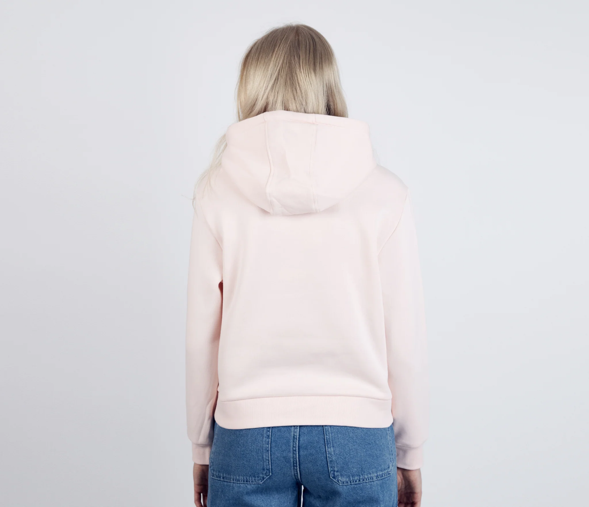 Woman wearing the light pink Moomintroll's Adventure hoodie - back view