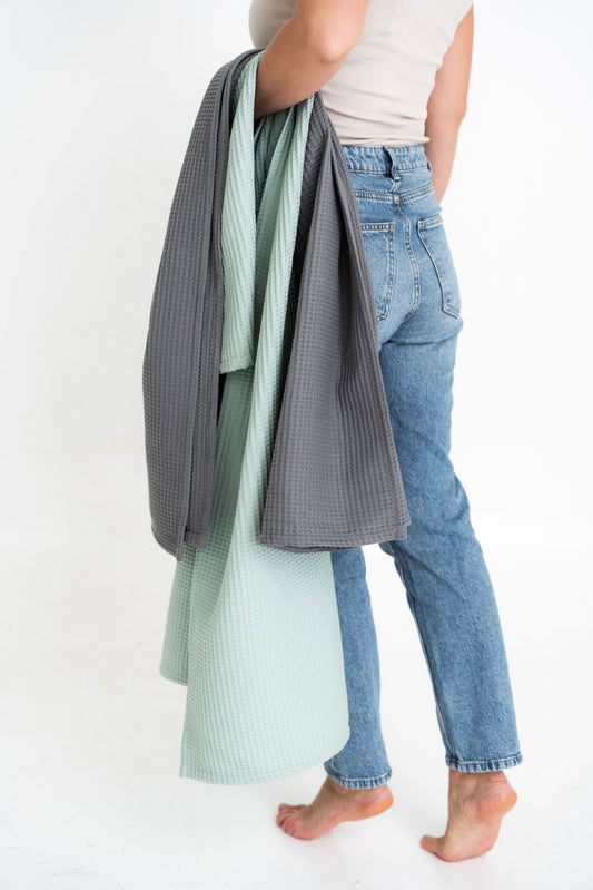 Woman Holding Sage Green Organic Waffle Cotton Towels Under Arm \| NUSS |