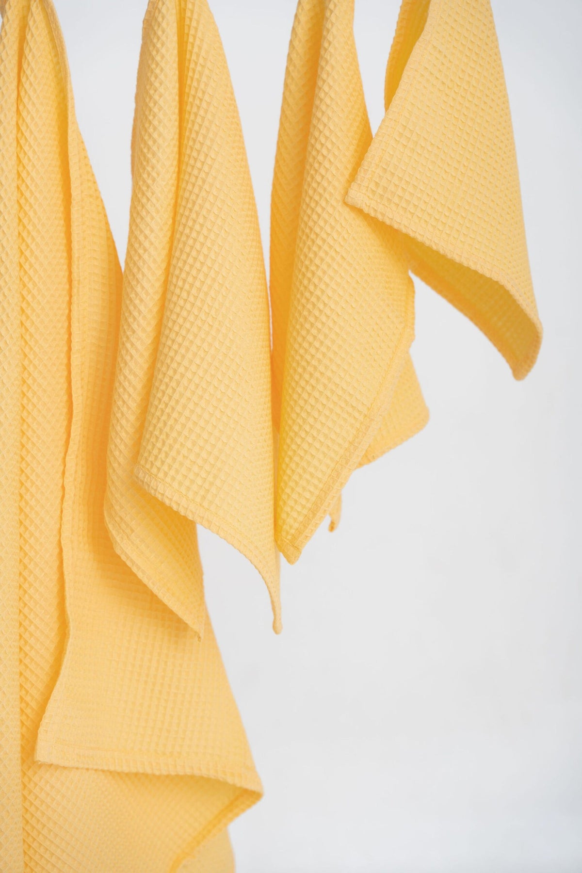 Close-Up View of Yellow Organic Waffle Cotton Towels Hanging | NUSS