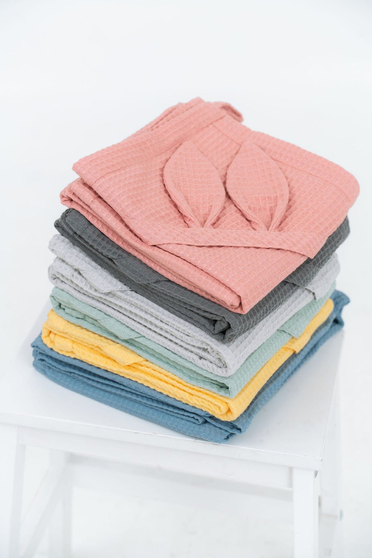 Medium View of Stacked Organic Waffle Bunny Ear Towels on White Chair | NUSS