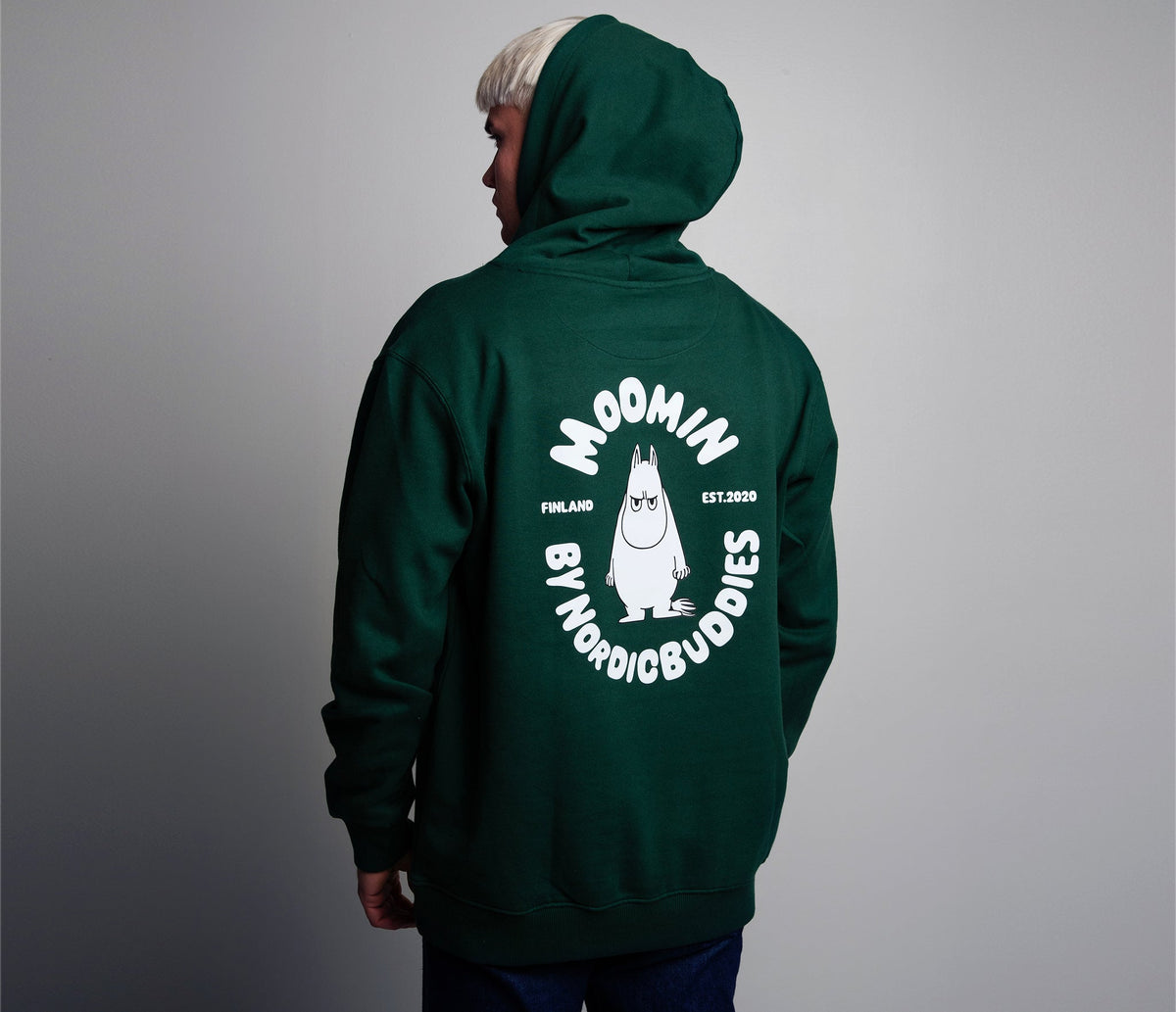 Model wearing green official Moomin premium cotton hoodie in a casual setting back view