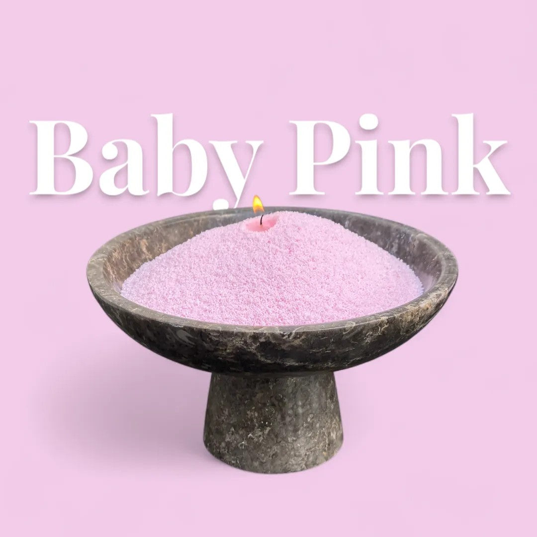Baby Pink text on a matching pastel pink background with a elegant vase full of unlit pearled candle sand in the foreground