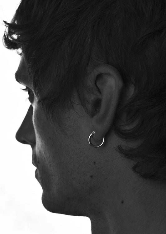 Close-up of a male model wearing the stylish silver Ella Hoops Earrings.