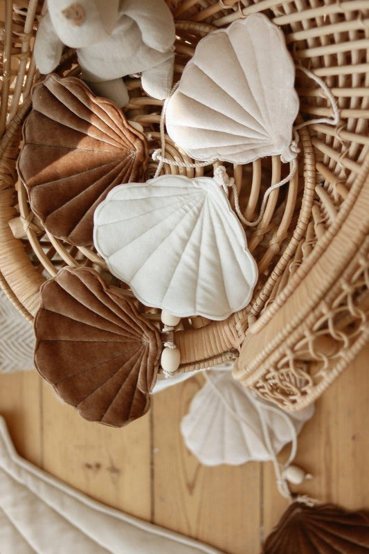 Detailed view of the matte beige cotton and shell-shaped fabric circles on a natural string