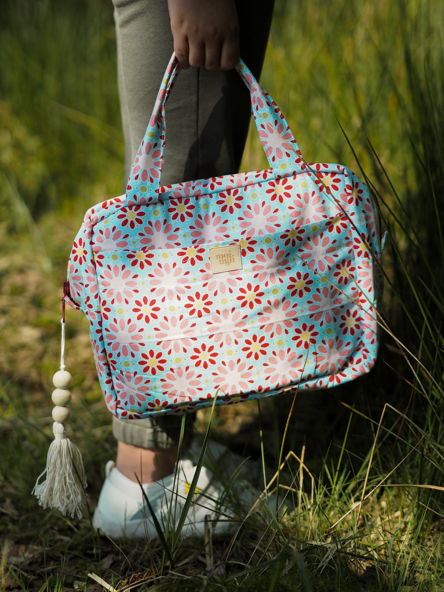 Lifestyle: Modern mother using the Red Flowers bag for baby skincare