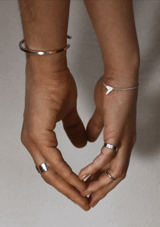 Close-up of a woman's wrist gracefully wearing the minimalist silver Love Bracelet.