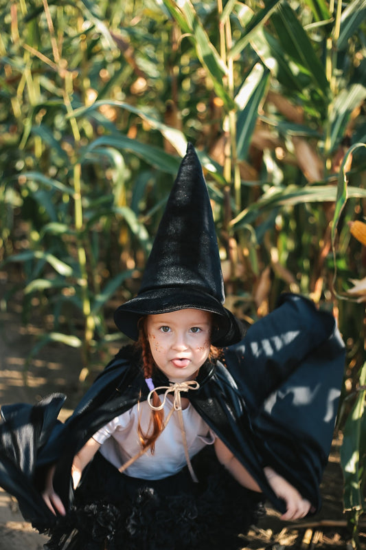 Moi Mili Black Magic Cape: a child runs wildly through a sunny forest