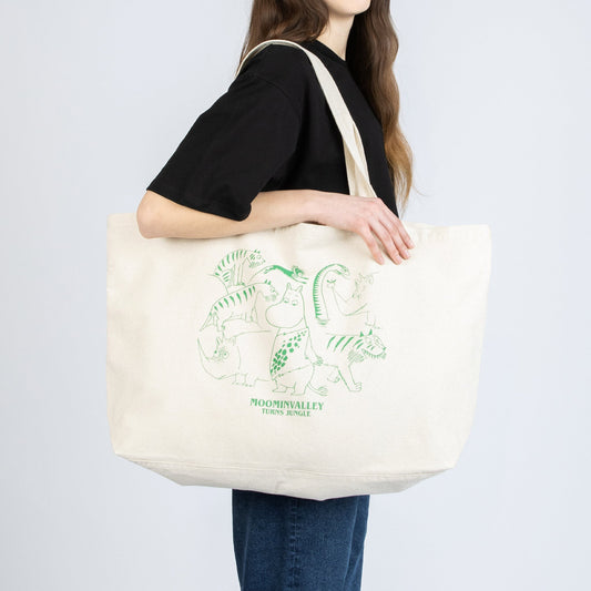 Side view of a girl holding the oversized Moomin Jungle tote bag by Nordicbuddies