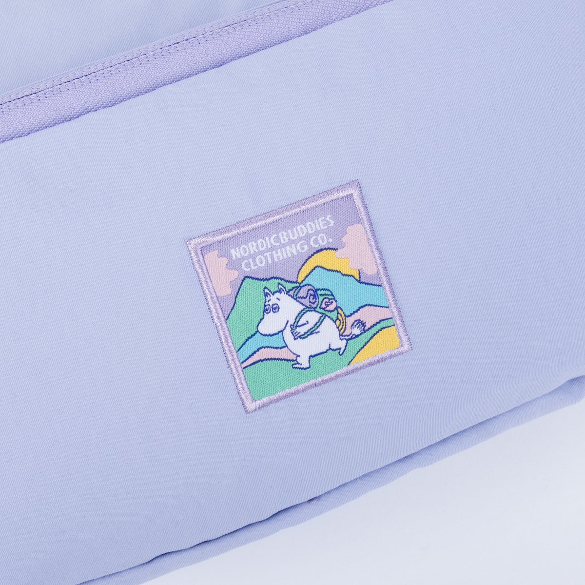 Close-up shot of the embroidered Moomintroll artwork, retro fabric texture, on the waist bag