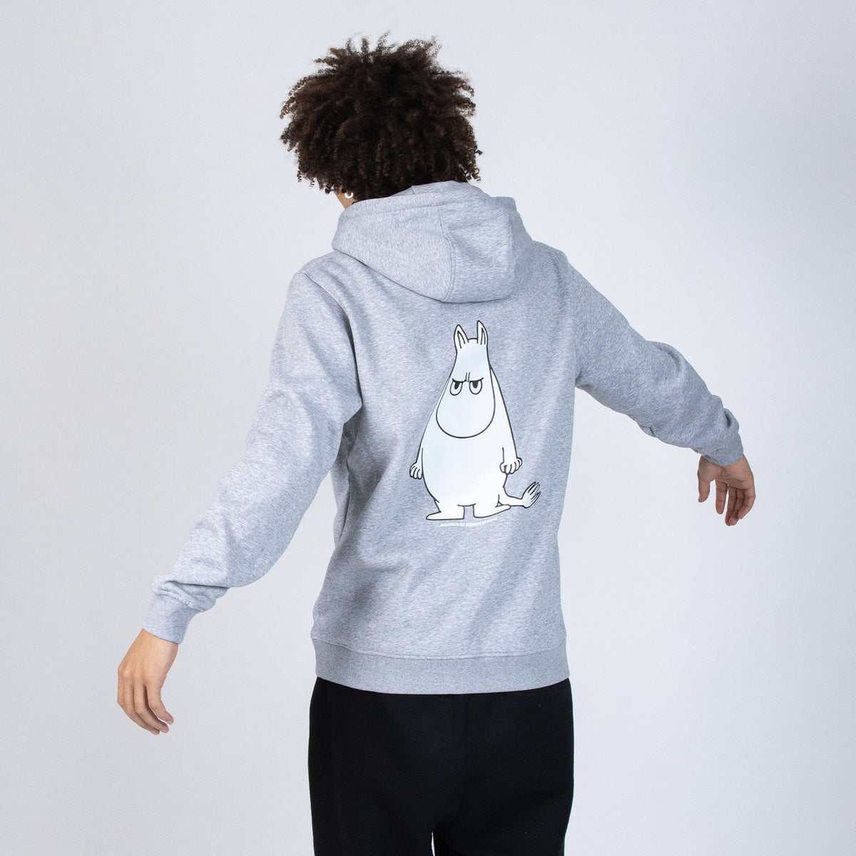 Different view of Male model wearing the grey Moomin Temper hoodie on a clean background