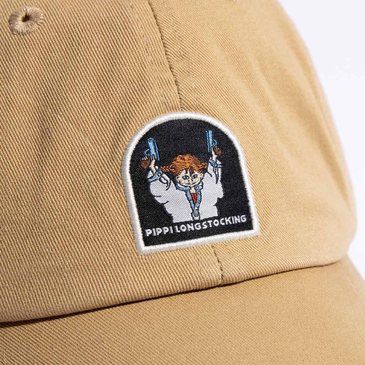 Close-up of embroidered Pippi And The Bang graphic design on cotton dad cap