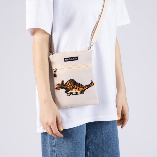 Person wearing the beige Pippi Longstocking crossbody passport bag in a casual travel setting