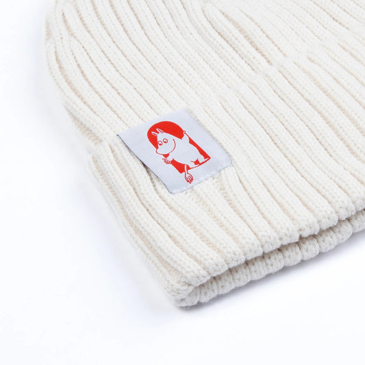 Close-up of embroidered Moomin x Red Cross patch on white ribbed knit beanie fabric