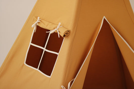 Nursery detail: close-up of the charming side window on a Moi Mili Ochre Teepee Tent, letting warm natural light into the mustard yellow play space