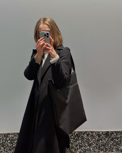 Model posing with compact VIK Small Tote Bag, minimalist vegan felt handbag