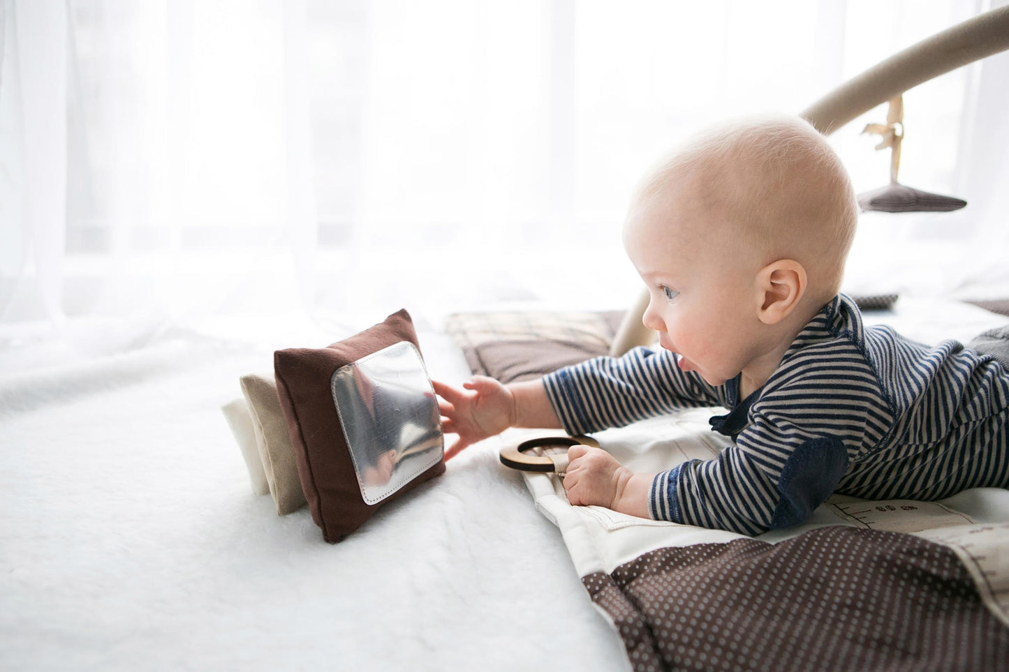 Baby plays with his reflection on Karloova handmade soft fabric stacking tower toy for babies