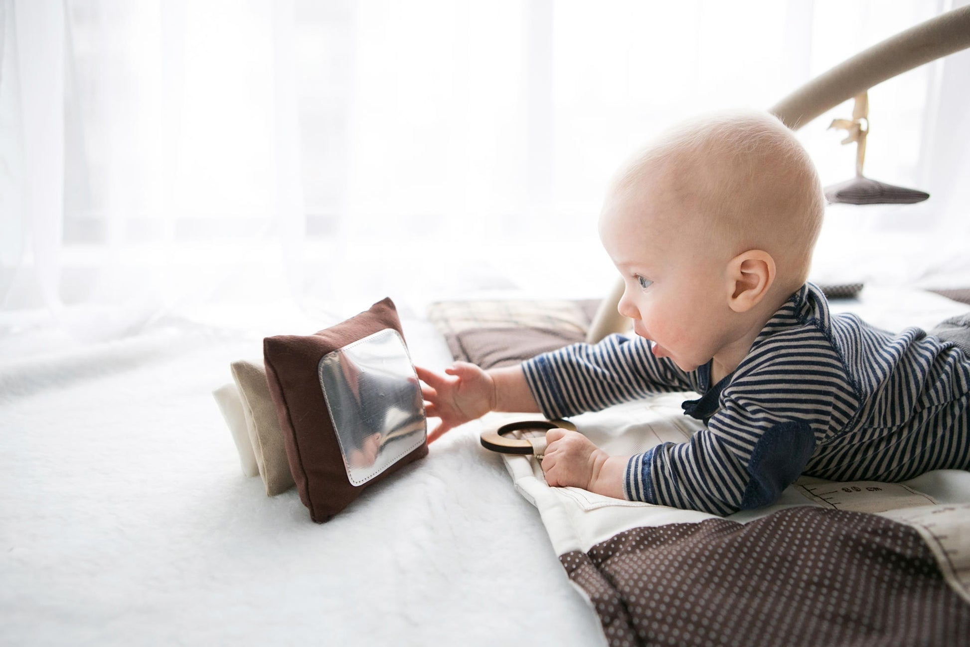 Baby plays with his reflection on Karloova handmade soft fabric stacking tower toy for babies