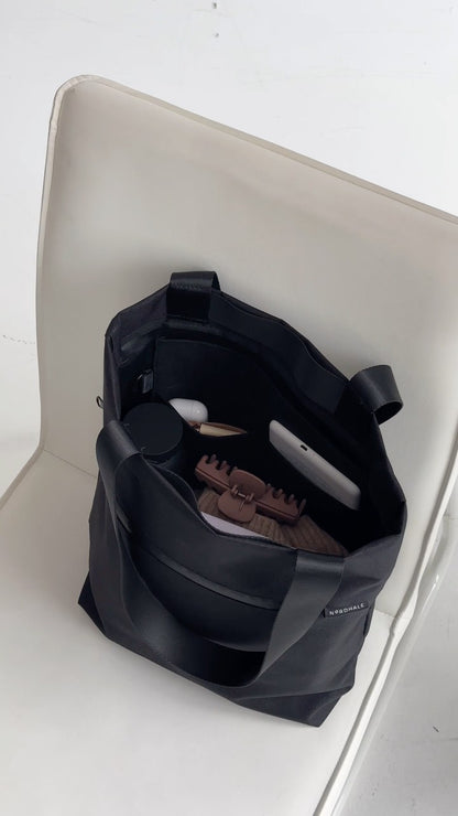 Open VIK Small Tote Bag in recycled felt resting on a minimalist white chair, interior view