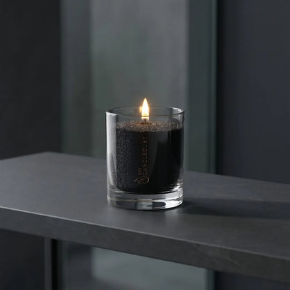Lit Candledust Black pearled glass candle burning cleanly on an elegant black surface