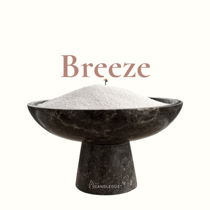 Breeze text on a matching fresh background with a glass vase full of unlit pearled candle sand in the foreground