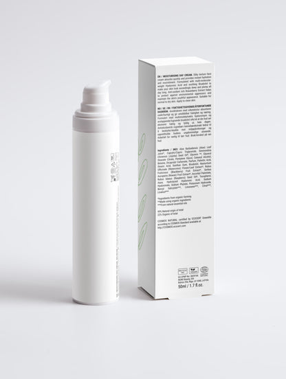 A white cylindrical pump bottle and its matching white product box with black text and light green leaf graphics, photographed on a clean light gray studio background.