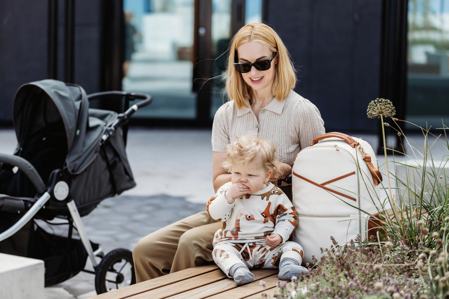 Family sitting in a park with the Large Cappuccino Backpack holding baby essentials