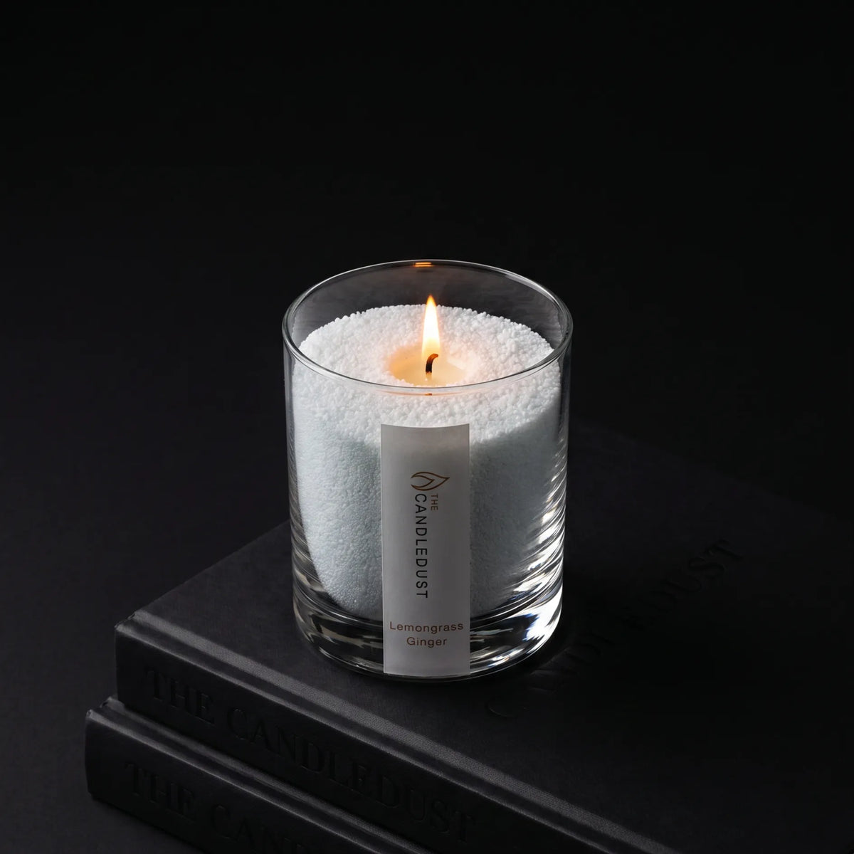 Lit Candledust Lemongrass Ginger scented pearled candle in a 160g glass jar on black background