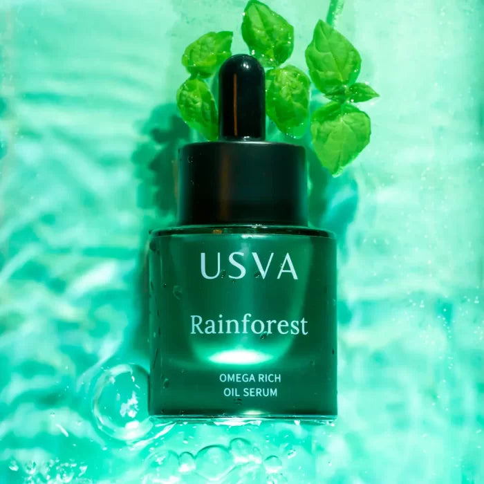 USVA Rainforest Omega Rich Oil Serum bottle with dropper on a green textured background