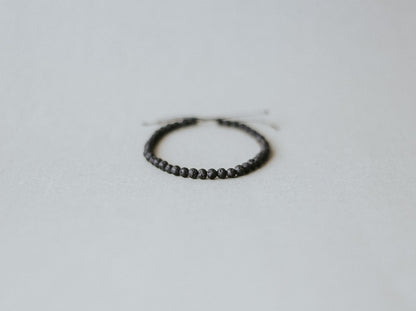 Top View of Adjustable minimalist bracelet with 4mm porous black lava beads on a durable cord