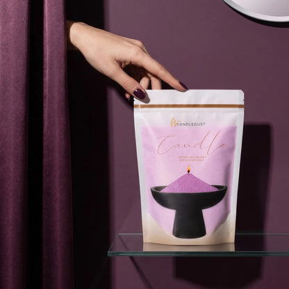 Woman's hand reaching from behind an amethyst purple curtain to touch a 1kg pearled candle sand refill pouch on a glass shelf