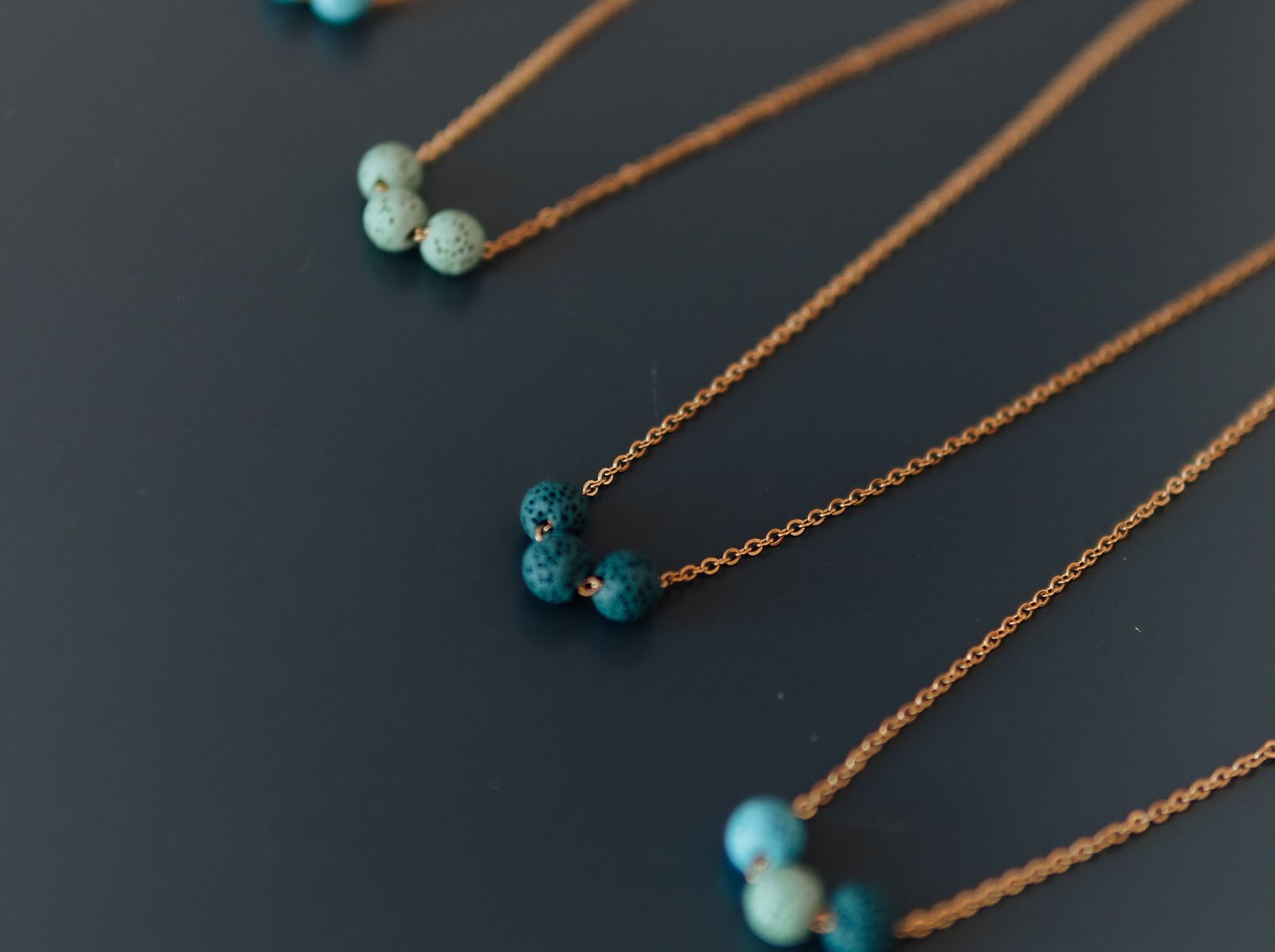 Perspective view of the minimalist lava stone diffuser necklace showing bead size and chain length