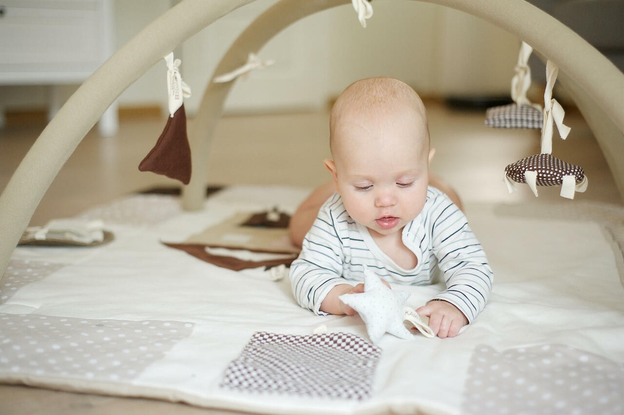 Close-up of Handmade Nordic design baby play gym for newborn tummy time and exploration 120x120cm - Brown