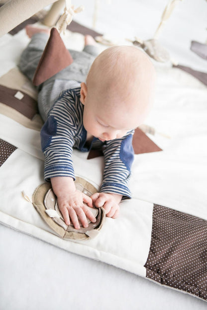 Bby playing on Karloova organic cotton baby activity mat with sensory play arches, 120x120cm - Brown
