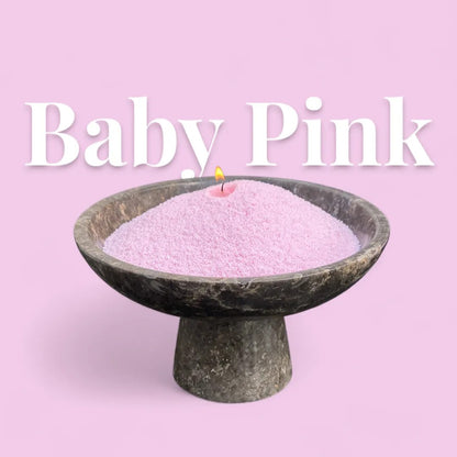 Baby Pink text on a matching pastel pink background with a elegant vase full of unlit pearled candle sand in the foreground