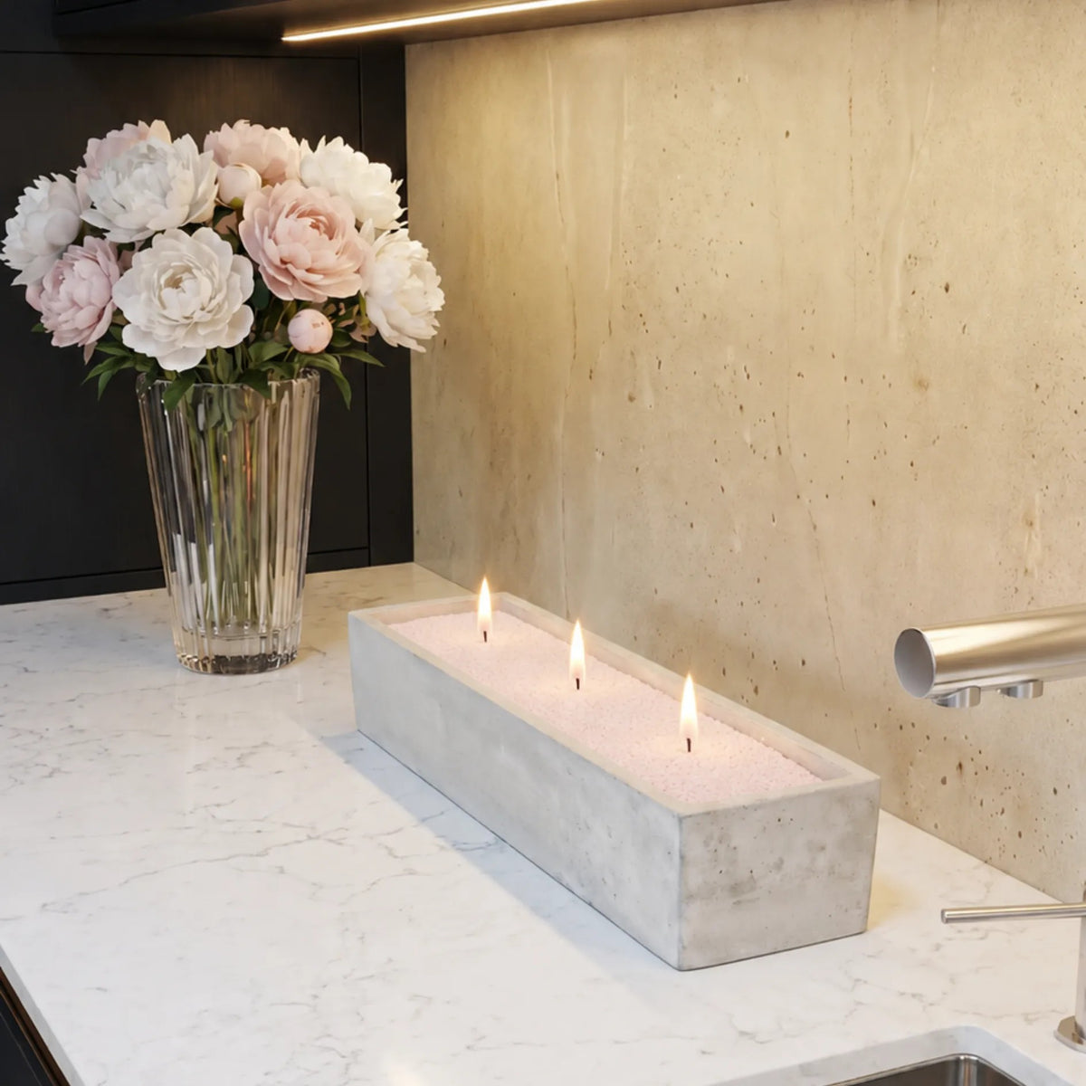 Elegant marble vase filled with Baby Pink pearled candle sand and lit cotton wicks resting on a refined marble countertop