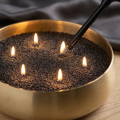 Close-up of a hand lighting the cotton wicks of a Black pearled sand candle