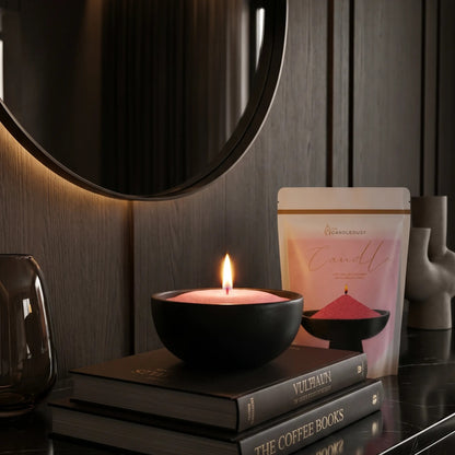 Lit Blush Vintage pearled sand candle displayed on a decorative vase resting on stacked books