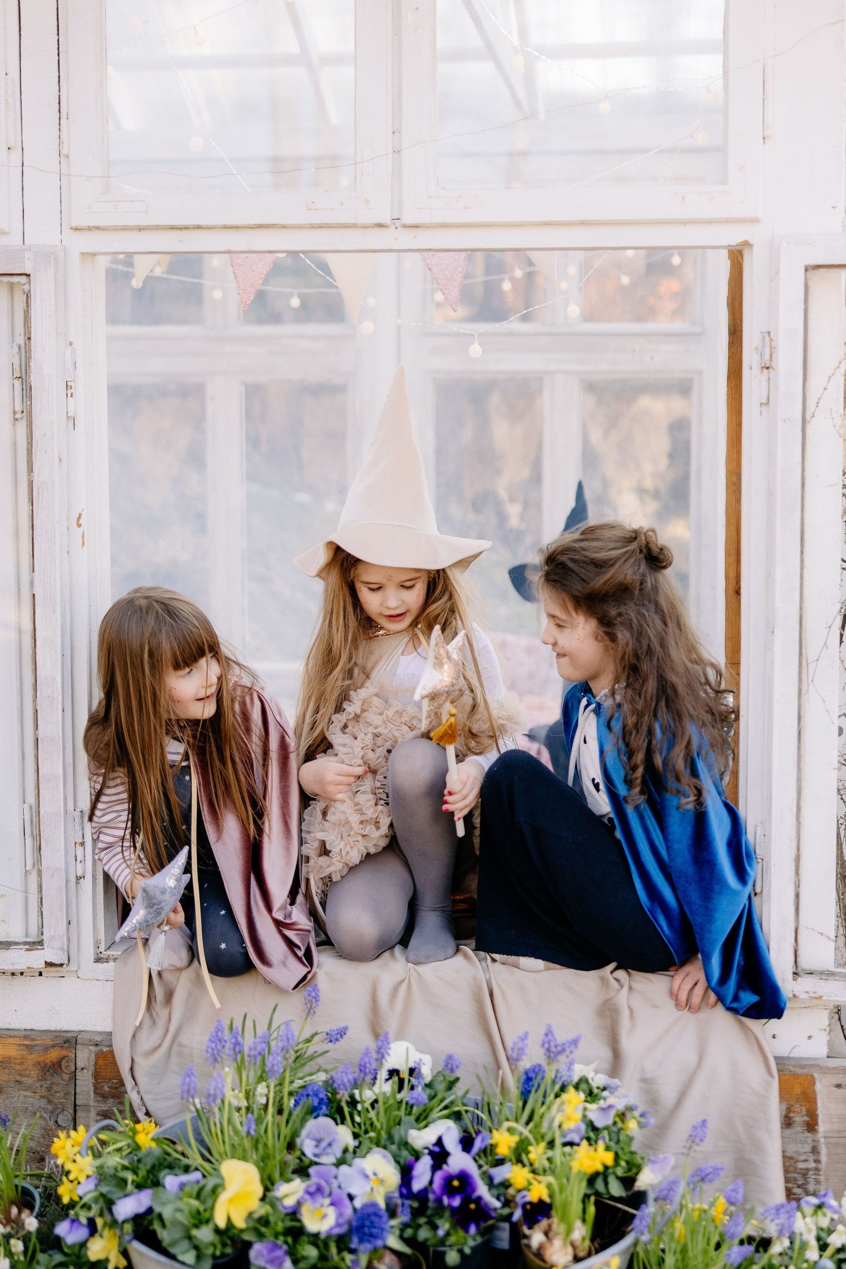 Pretend play scene: Toddler in a Rose Gold cat costume near a crib