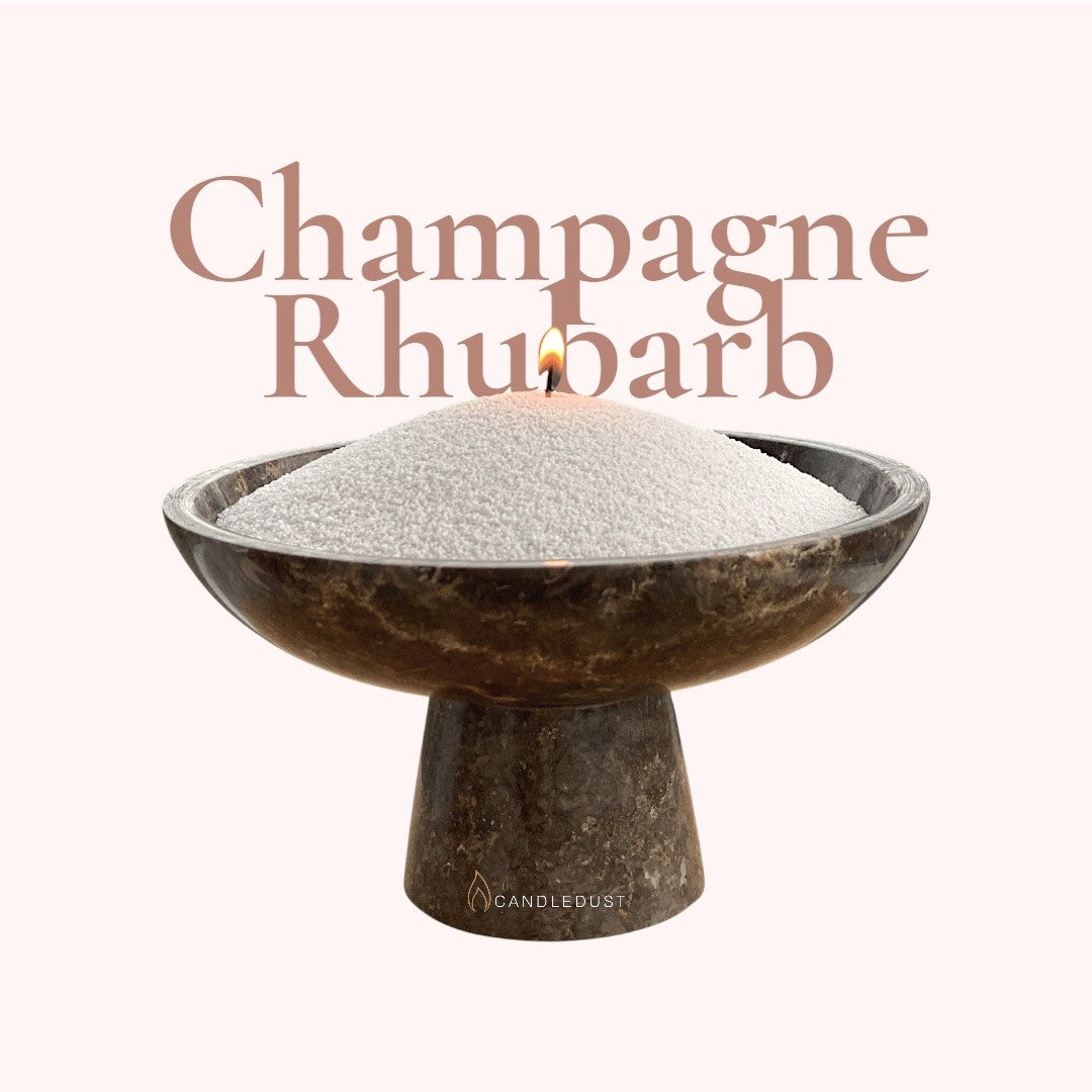 Champagne Rhubarb text on a matching elegant blush background with vase full of unlit pearled candle sand in the foreground