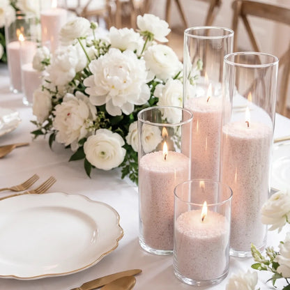 Glass vases of various heights filled with burning Champagne Rhubarb scented pearled candle sand creating a glowing cluster