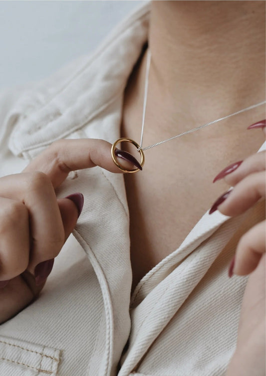 Close-up of a woman wearing the minimalist gold Circle Necklace on her collarbone.