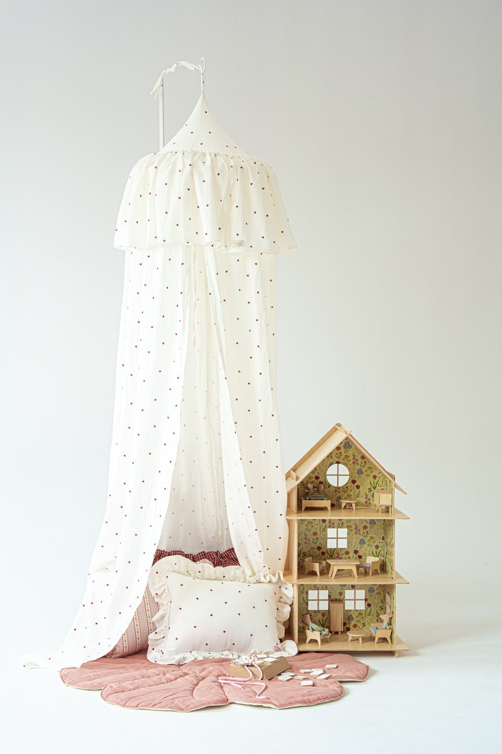 Romantic nursery decor featuring a heart print hanging canopy
