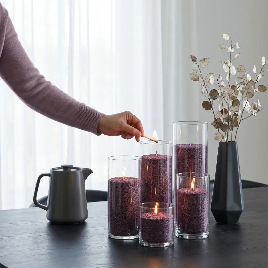Woman's hand lighting the cotton wick of a Dark Lilac pearled sand candle