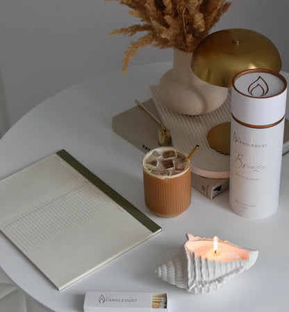 Candledust Dark Honey candle sand tube and lit pearled glass candle on a wooden dining table