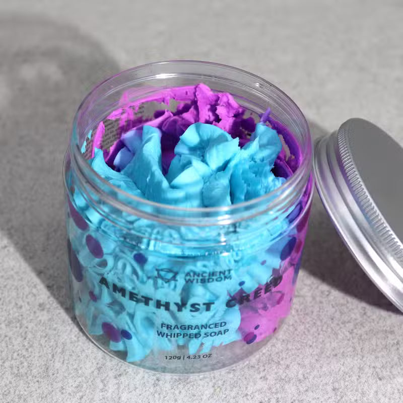 Top-down view of an open jar showing purple and pink swirled Amethyst whipped soap