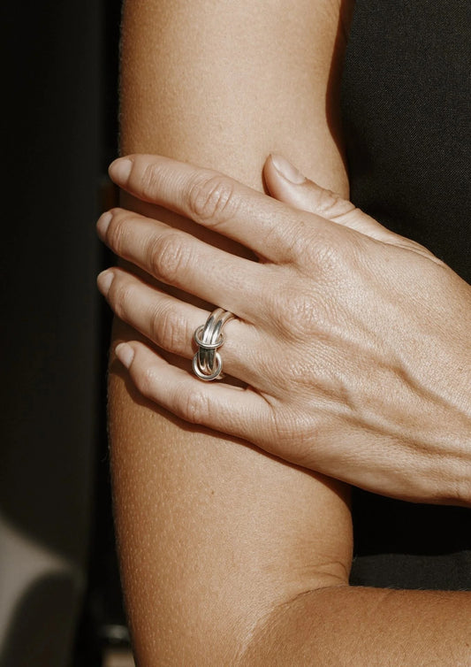 A model's hand gracefully wearing the minimalist silver Double Ring.