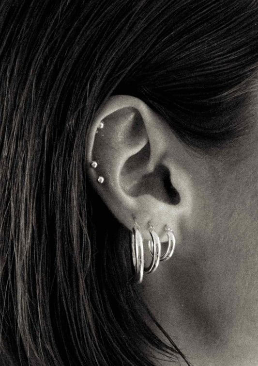 Close-up of a model wearing the stylish silver Ella Hoops Earrings