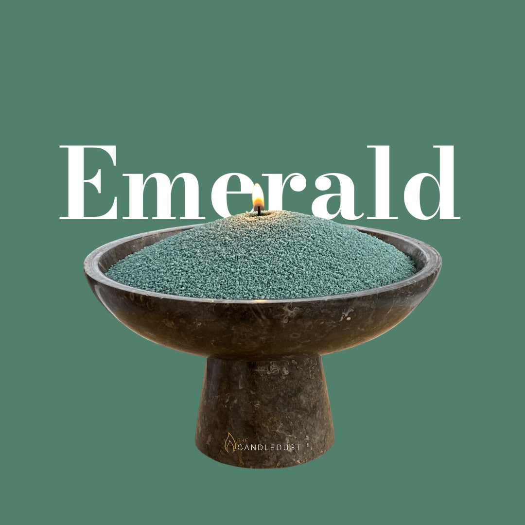 Emerald text on a rich emerald background with a glass vase of unlit pearled candle sand in the foreground