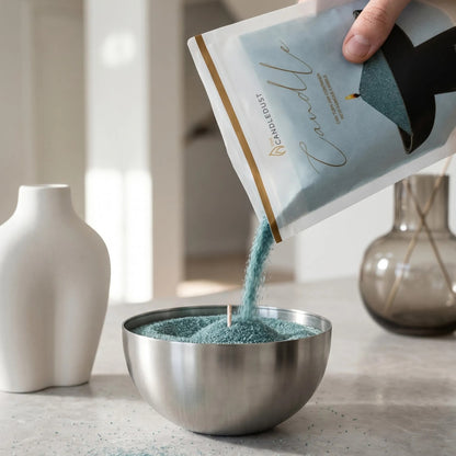 Man pouring Emerald pearled candle sand into a metal holder on a white table